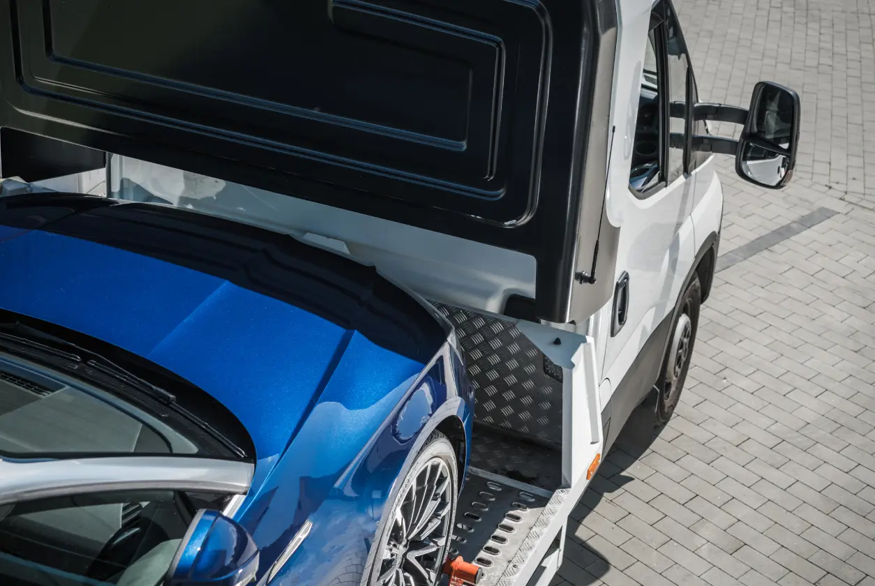 New Project (2) Tow truck carrying a blue car.