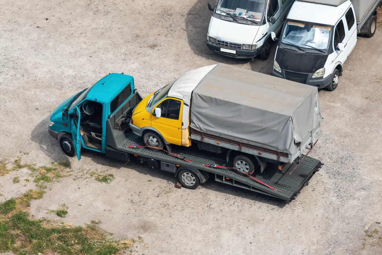 New Project (6) Truck loaded with small yellow vehicle.