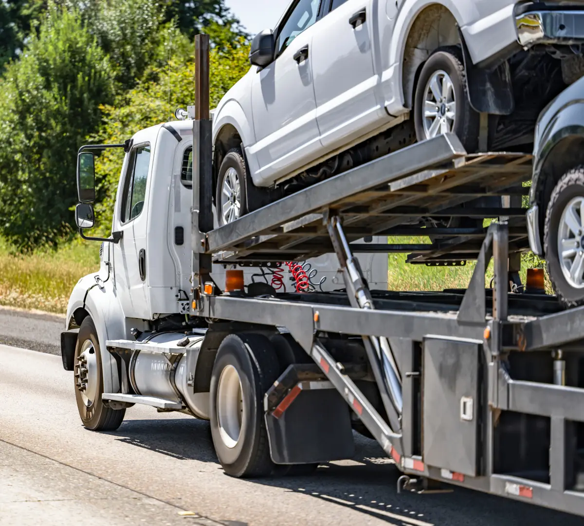 Truck transporting cars on highway.