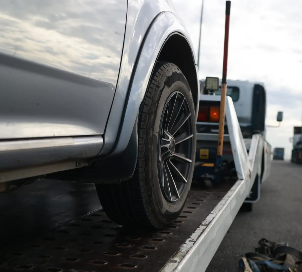 Car being towed on a flatbed truck.